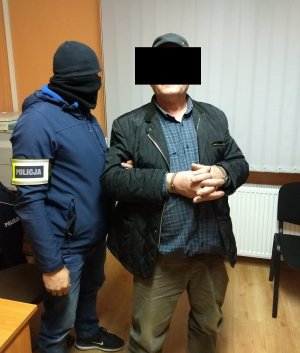 Policjant prowadzi zatrzymanego