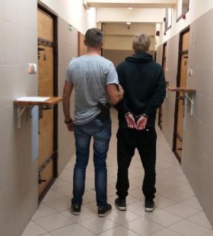 Policjant  prowadzi zatrzymanego