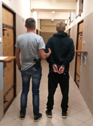 Policjant  prowadzi zatrzymanego