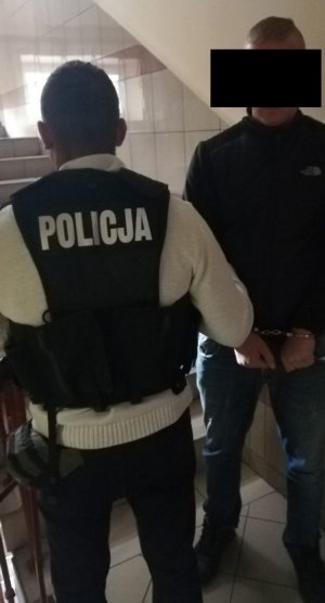 Policjant prowadzi zatrzymanego