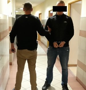 Policjant prowadzi zatrzymanego