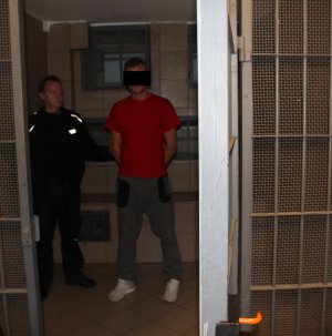 Policjant prowadzi zatrzymanego