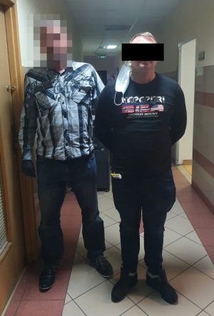 policjant prowadzi zatrzymanego