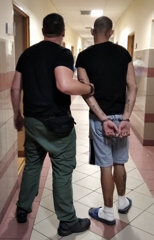 policjant prowadzi zatrzymanego