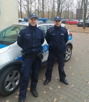 policjanci na tle radiowozu