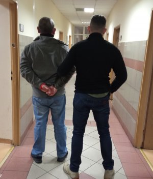 policjant prowadzi zatrzymanego