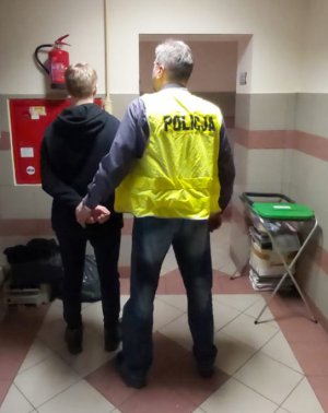 policjant prowadzi zatrzymanego
