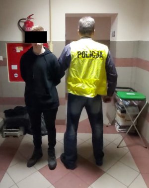 policjant prowadzi zatrzymanego