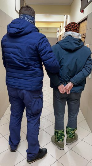 policjant prowadzi zatrzymanego
