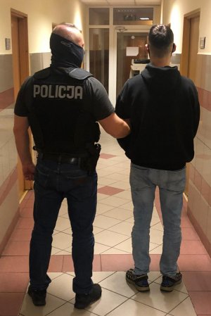 policjant prowadzi zatrzymanego