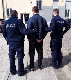 policjanci prowadzą zatrzymanego