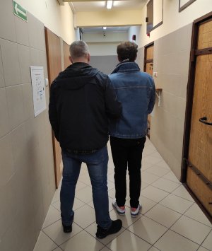 policjant prowadzi zatrzymanego